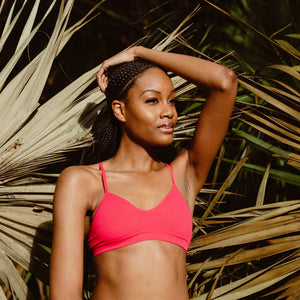 Guide to Bras for Small Boobs - girl standing in front of palm trees with wearing azalea colored elli bralette