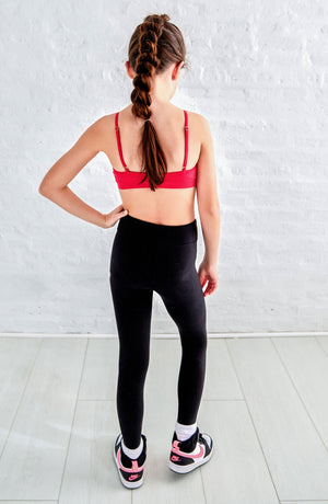 tween in black leggings and hot pink bralette