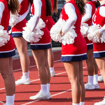 girls cheering at a game in their cheerleading uniforms