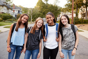 image of teens smiling with their bookbags on