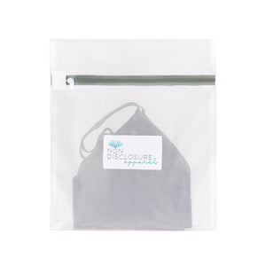 Non Disclosure Apparel mesh wash bag containing a grey concealing bralette to protect it during the laundry cycle.