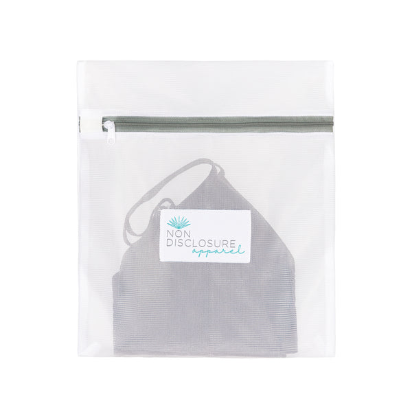Non Disclosure Apparel mesh wash bag containing a grey concealing bralette to protect it during the laundry cycle.