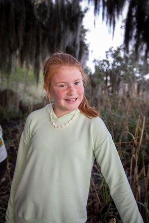 tween smiling at camaera by a marsh